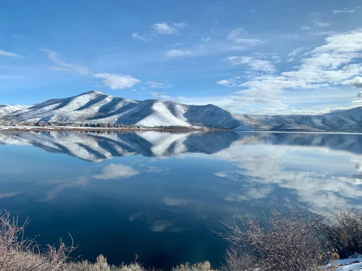 the mountains are reflected in the water on a sunny day