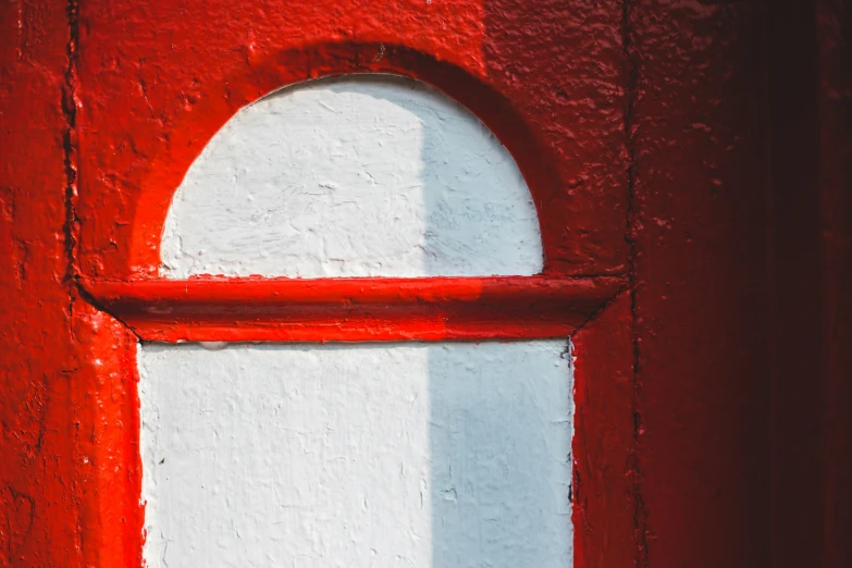 a red and white door with a round window frame