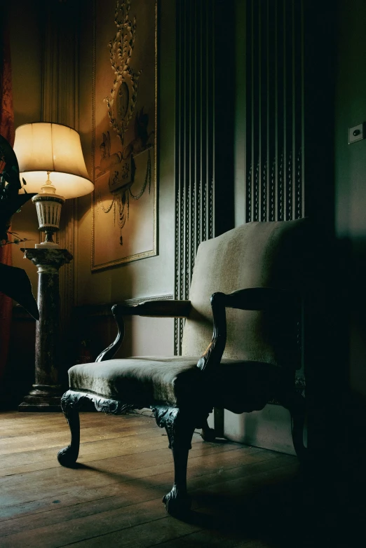 the dark room with a chair and a lamp on