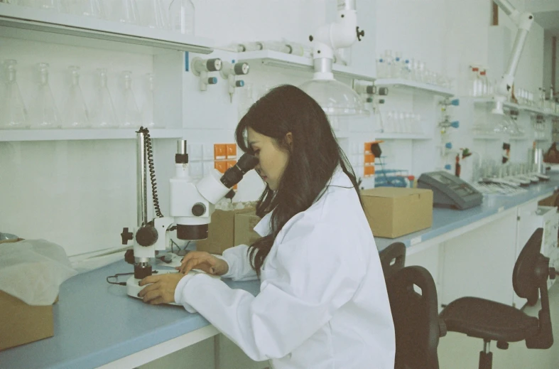 a woman in a lab working with microscopes