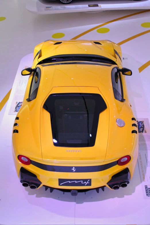 yellow sport car with a black stripe is on display