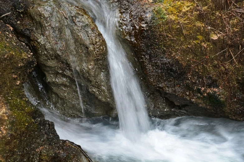 a tall waterfall cascades down the side of a rock face