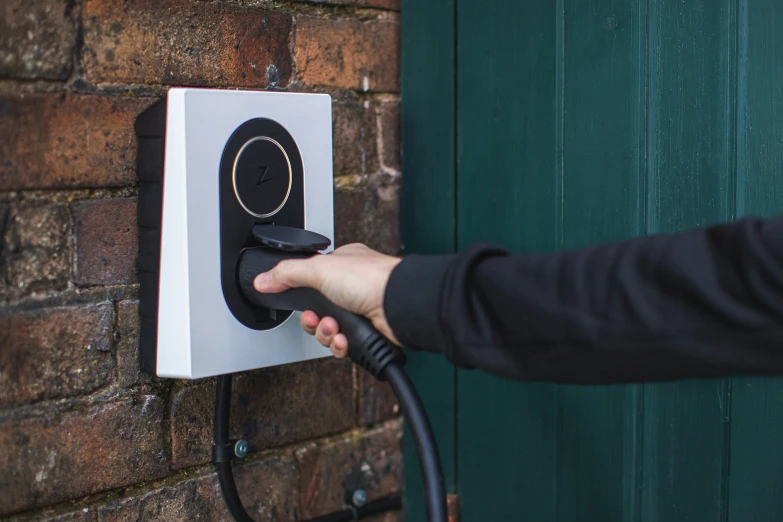 a person is holding the handle on a wall outlet