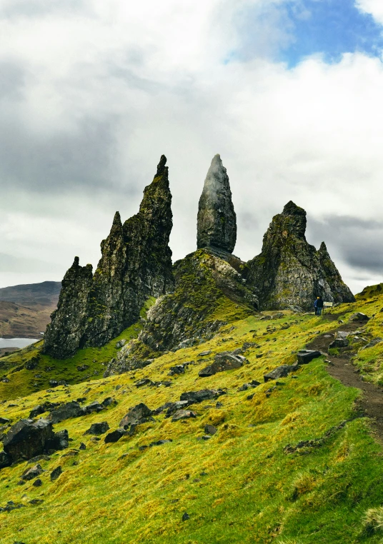 a grassy area on the side of a large rock formation