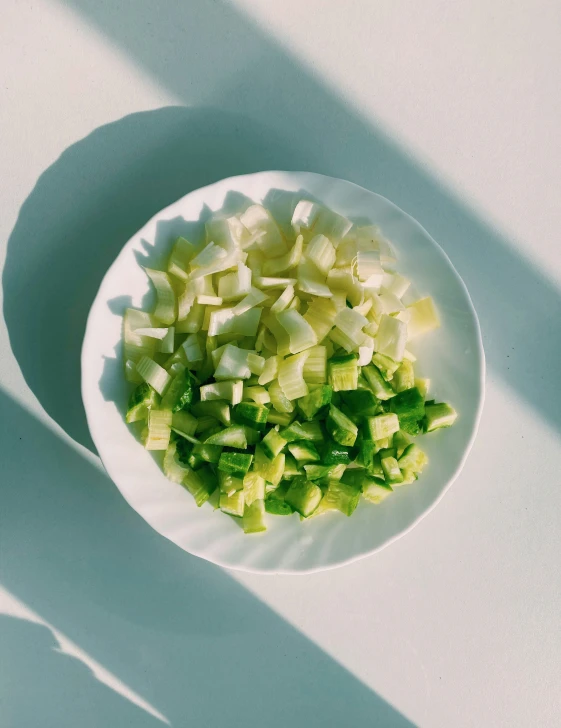 chopped up celery sitting on a white plate