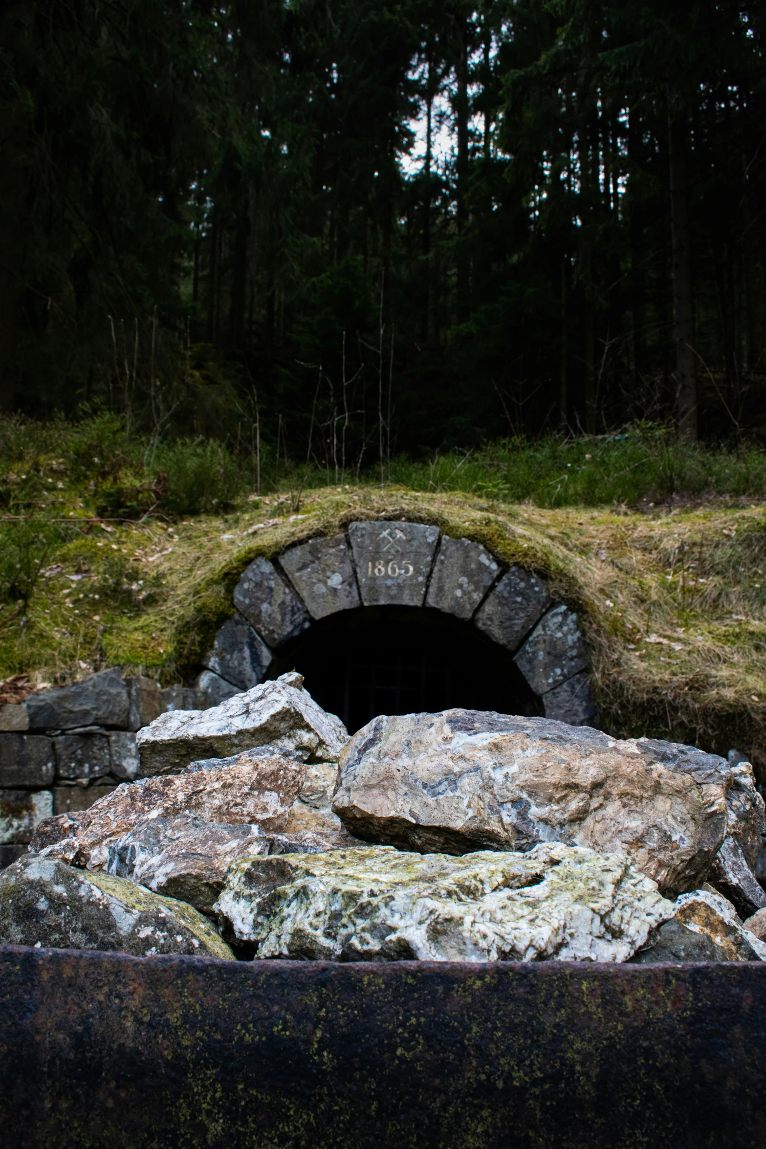 a stone and rock oven set in a patch of grass