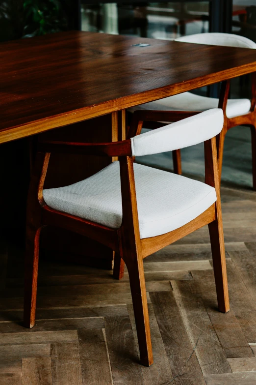 chairs sit at a very large table in the middle of a room