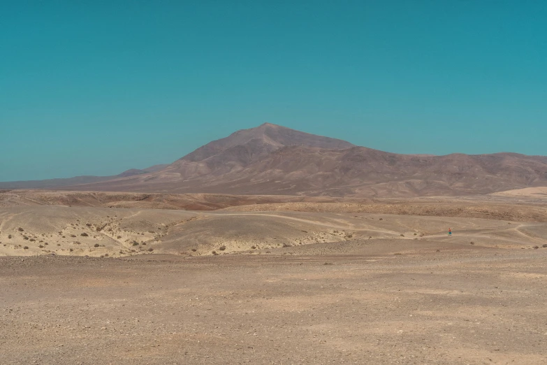 a desert landscape with sand and large mountains