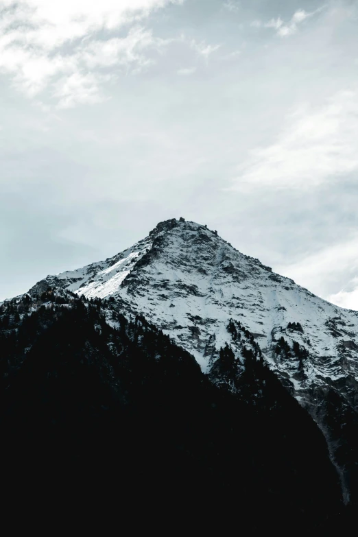 a mountain with a few clouds in the sky