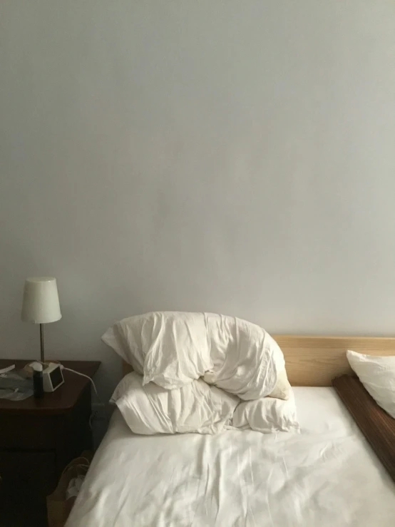 the white sheets and pillows are stacked together