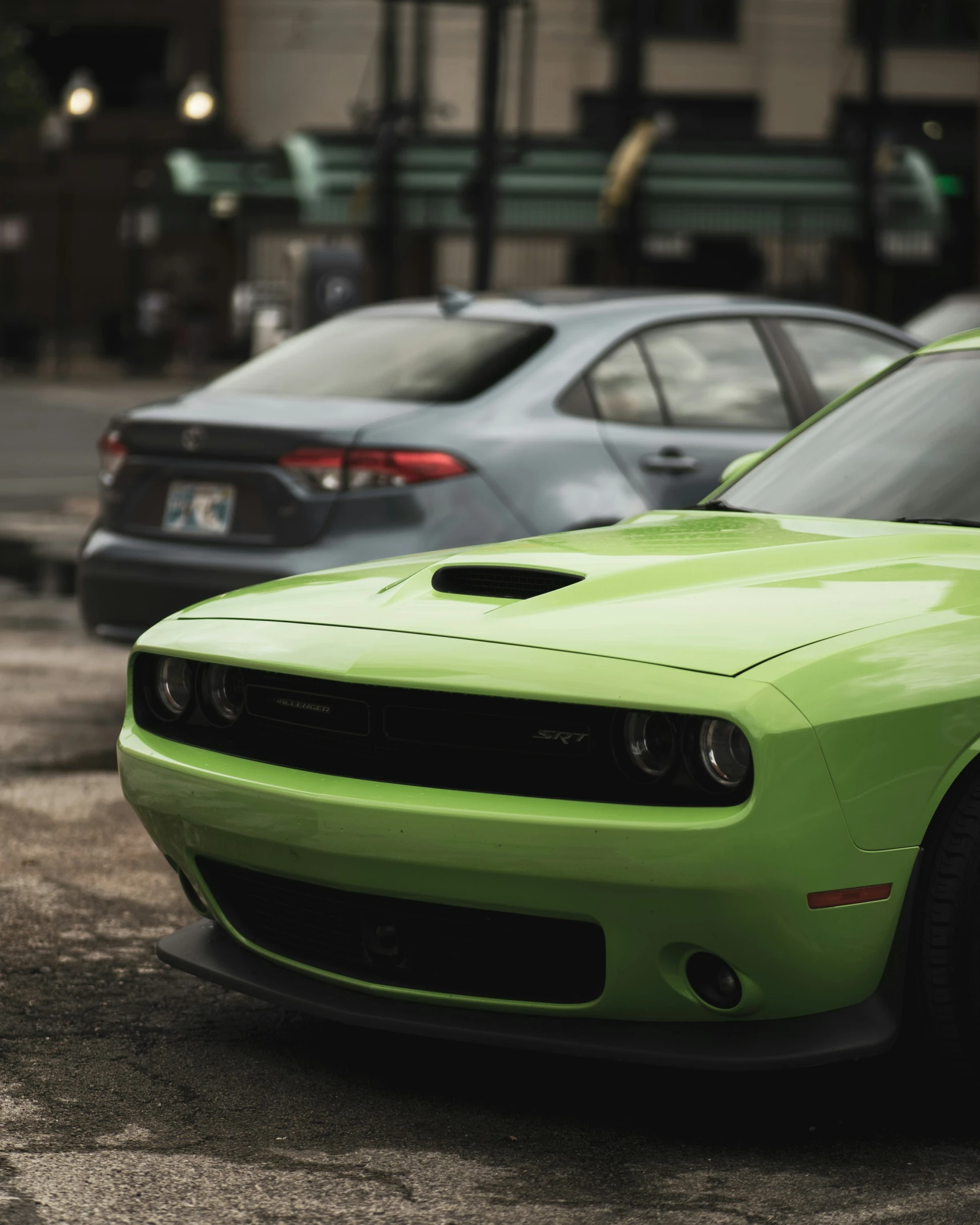 a green car parked next to several other cars