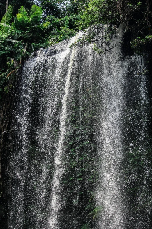 a waterfall is shown with people standing at the bottom