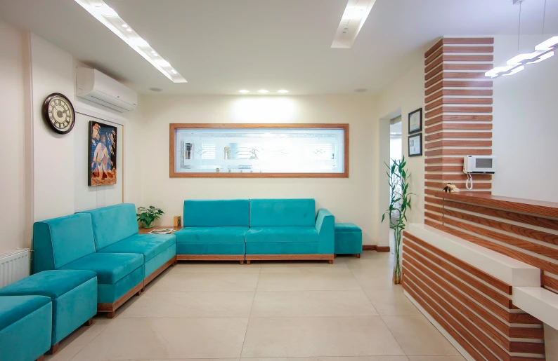 a living area with bright turquoise sofas next to a flat screen tv