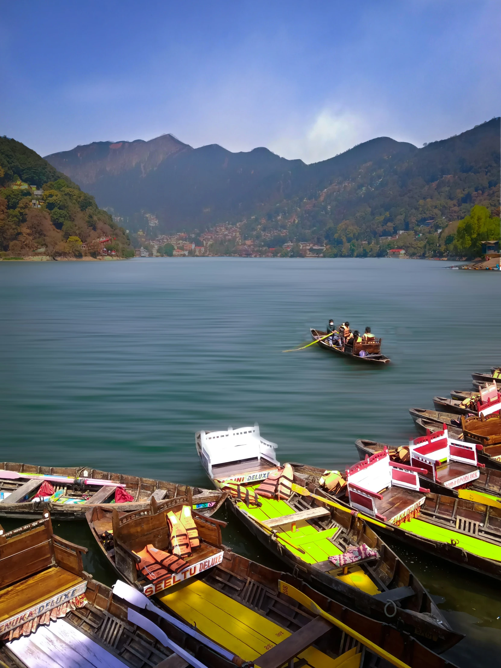 a row of boats sitting next to a pier near mountains