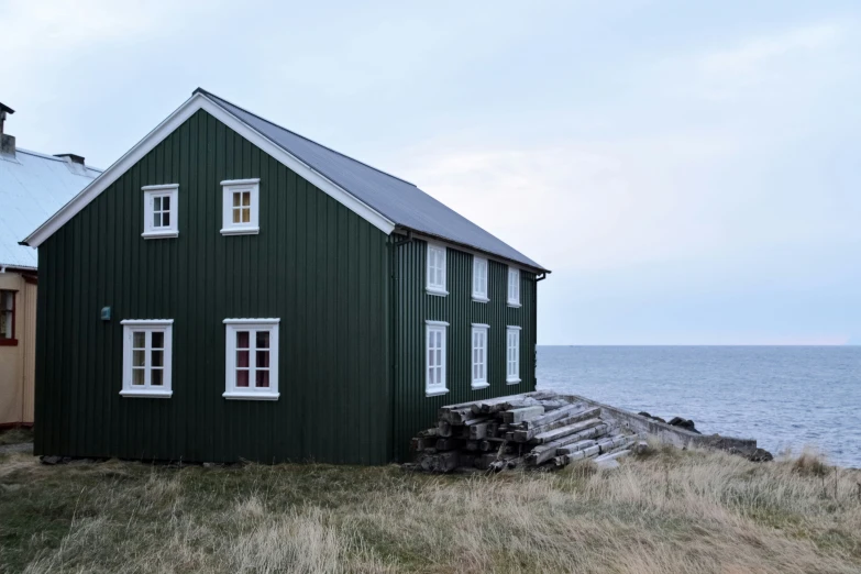 there is a green and white house on a hill