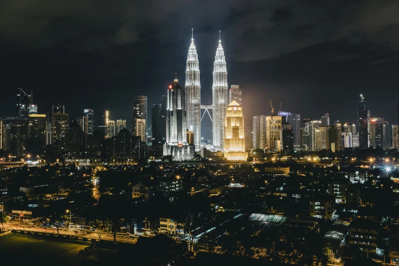 the view from a high rise building at night, of a city with lights all around