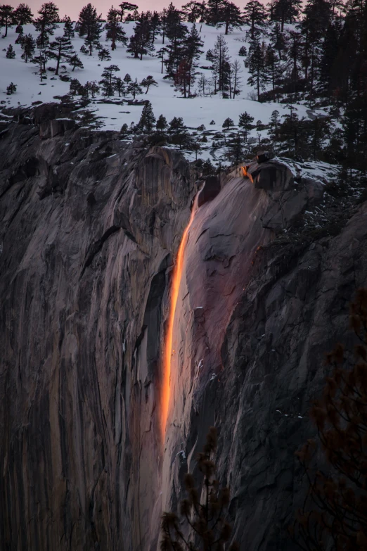 an icy mountain landscape features a waterfall at night