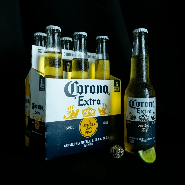 six corona beer bottles, one is empty and the other is full