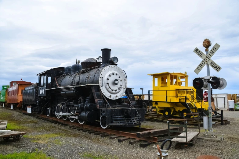 a black train engine sitting on the track next to a yellow car