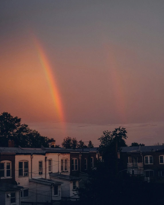 a rainbow that is in the sky with houses
