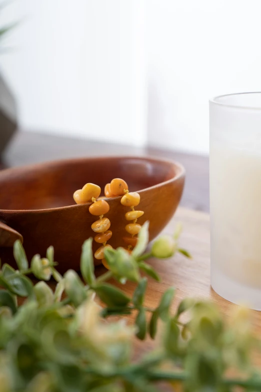 a white glass with some yellow flowers next to it