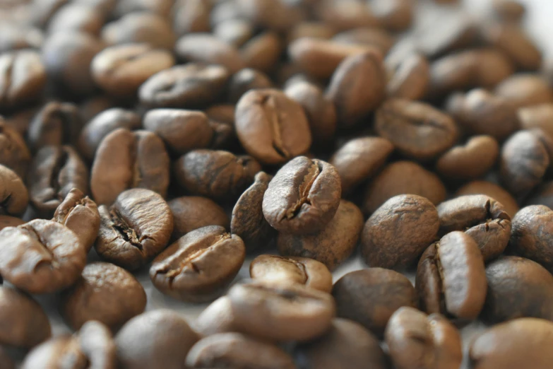 coffee beans are gathered together on a table