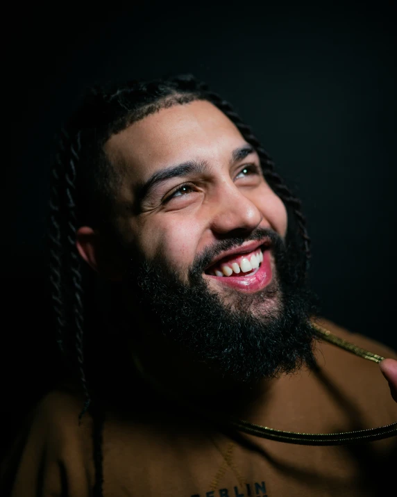 a young man with dreadlocks and beard smiling