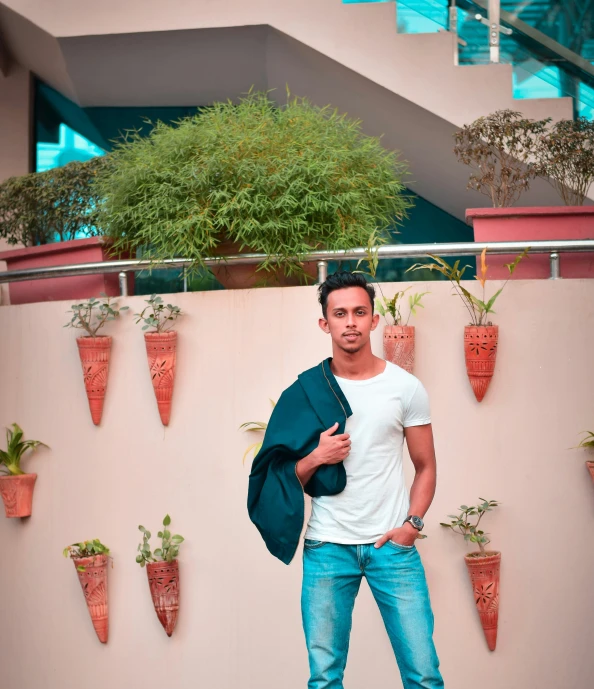 a young man with a denim jacket on leaning against a wall