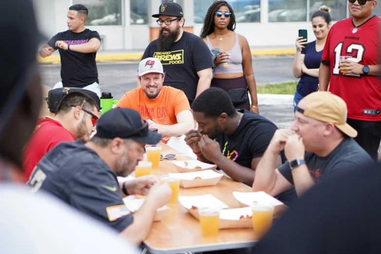 a group of men sitting around a table eating food