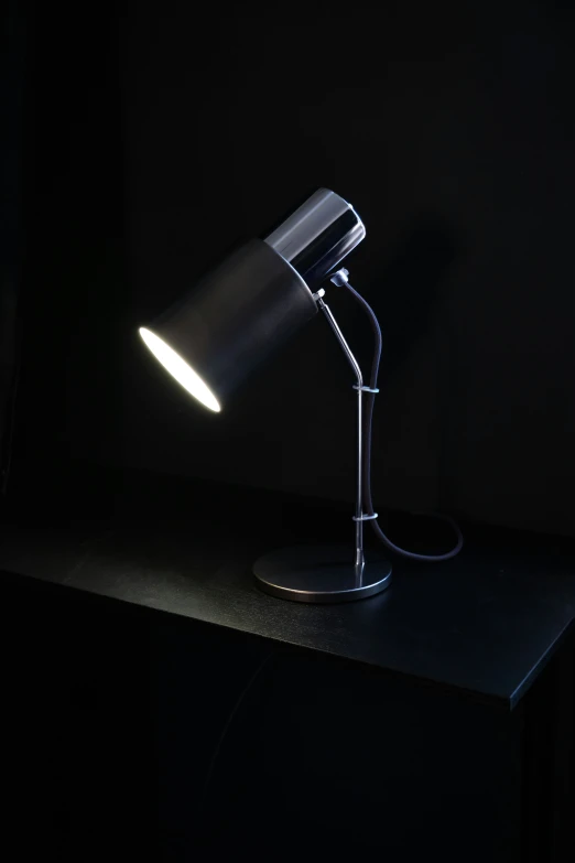 a desk lamp is sitting in a black room