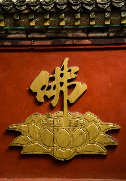 a golden symbol on the wall next to an oriental structure