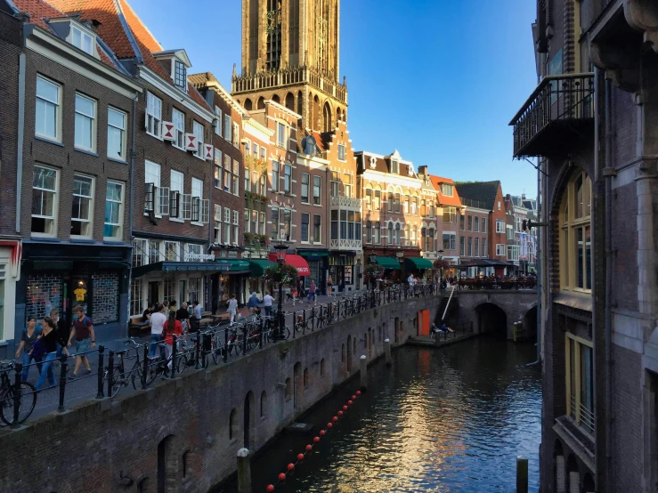 the tall tower with the clock is next to some water