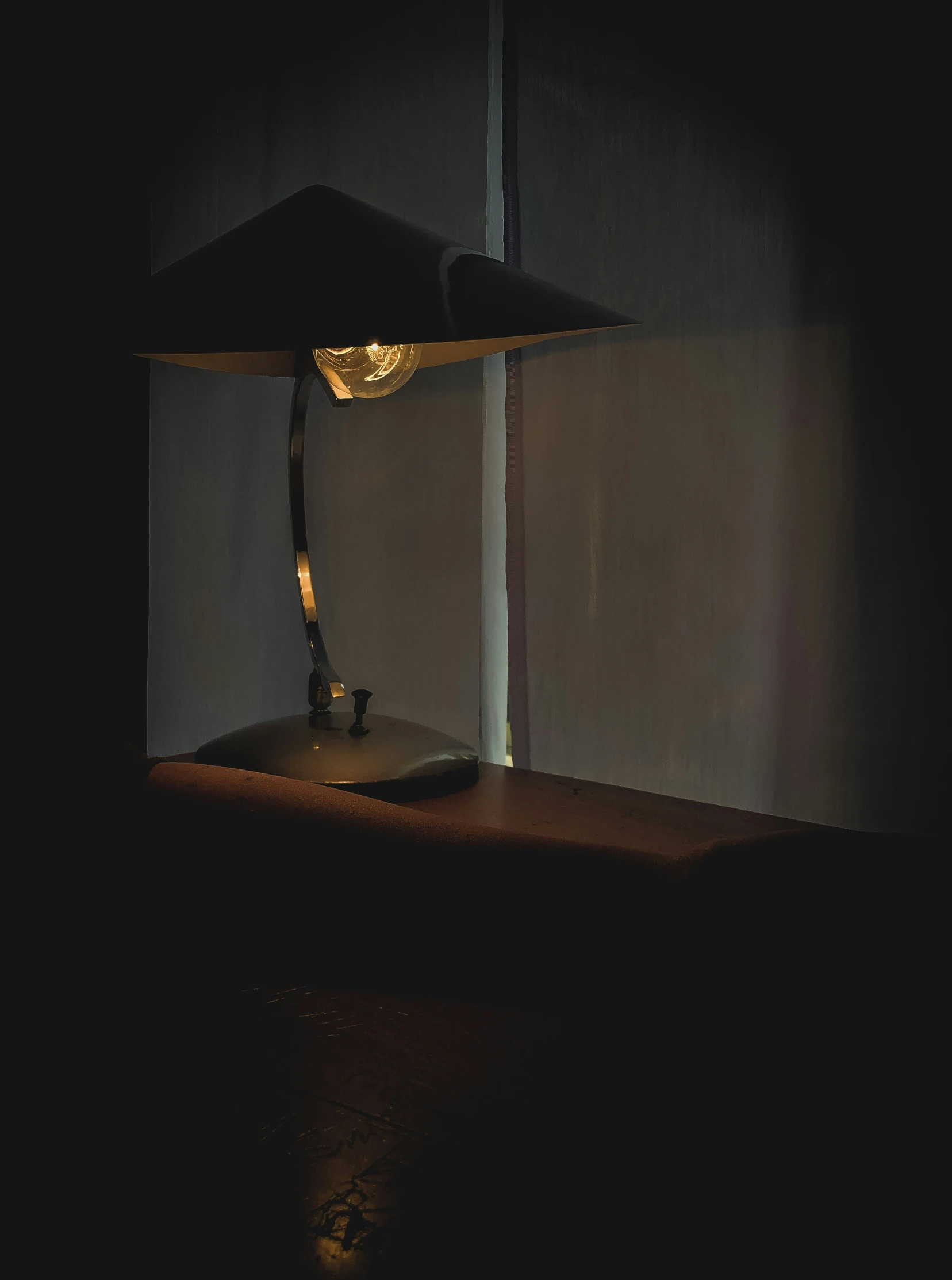 a lamp in the dark is on a table
