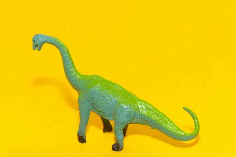 a toy dinosaur on a yellow background