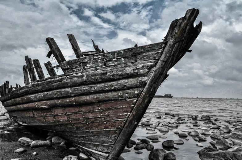 there is a boat sitting on the shore near the ocean