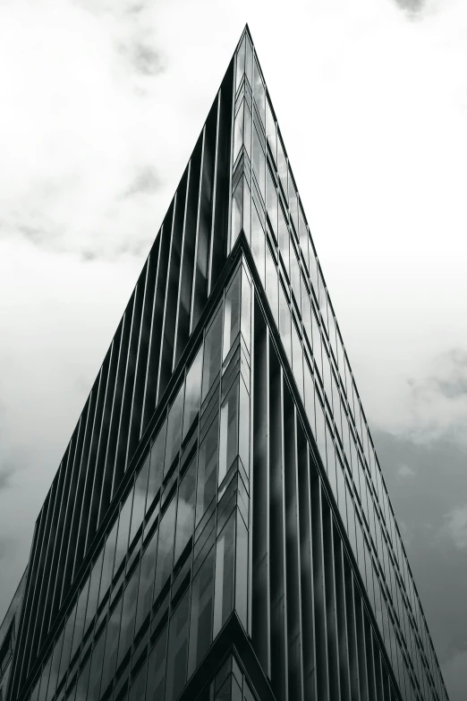 a skyscr building is pictured against a cloudy sky