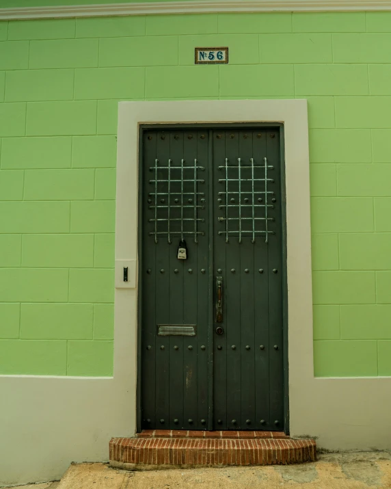 an old door in front of a green wall