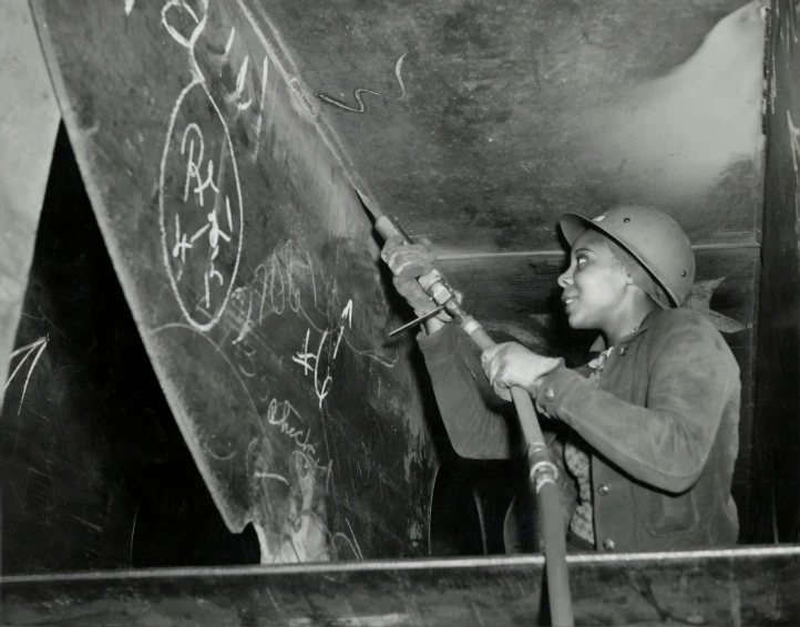 a man is writing on a blackboard in a room with chalk drawings