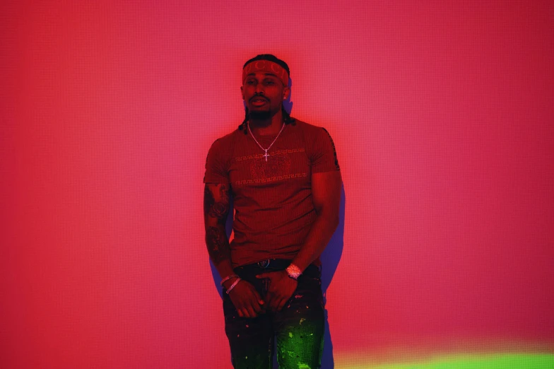 a man standing in front of pink and green wall