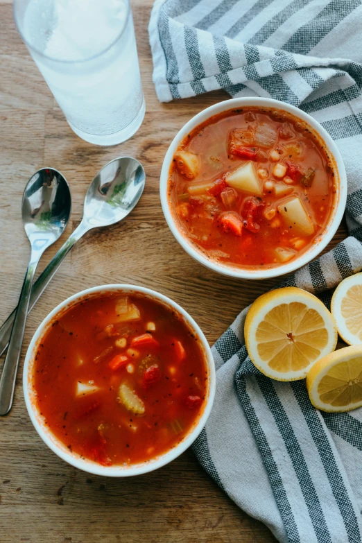 bowls of soup and silver spoons on a table