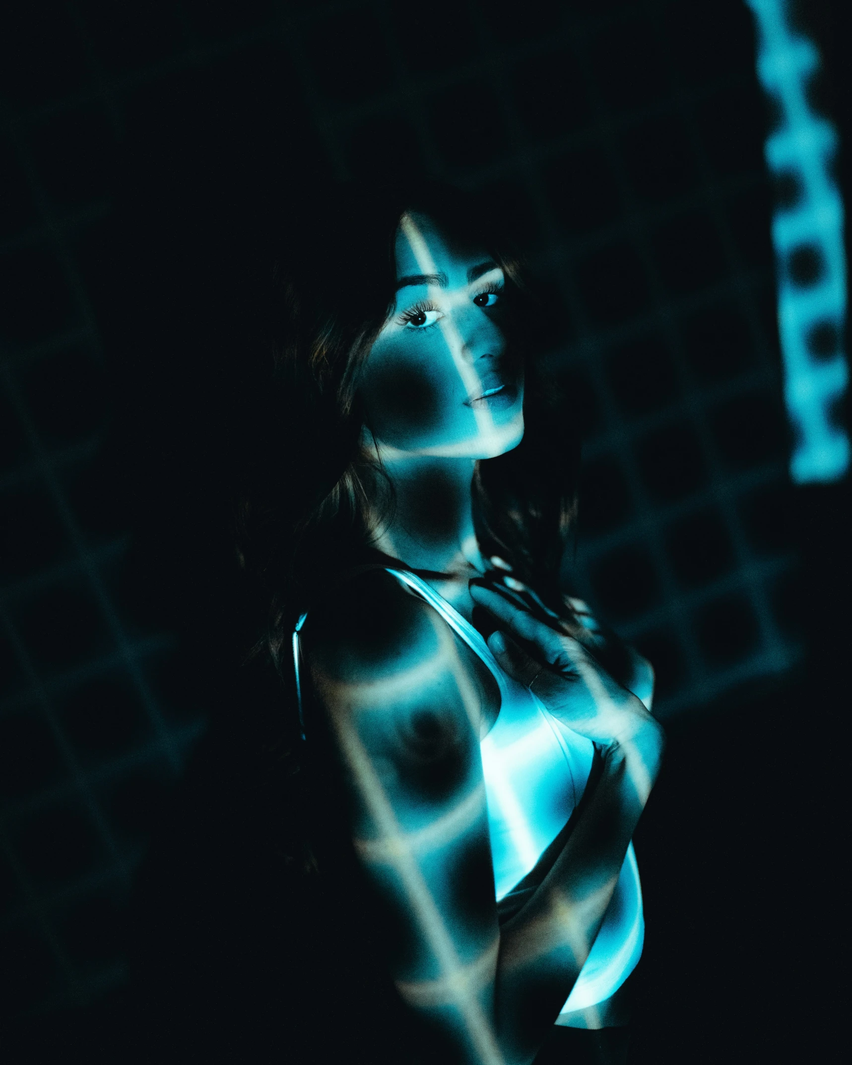 a woman is silhouetted against a wall and glows in the dark