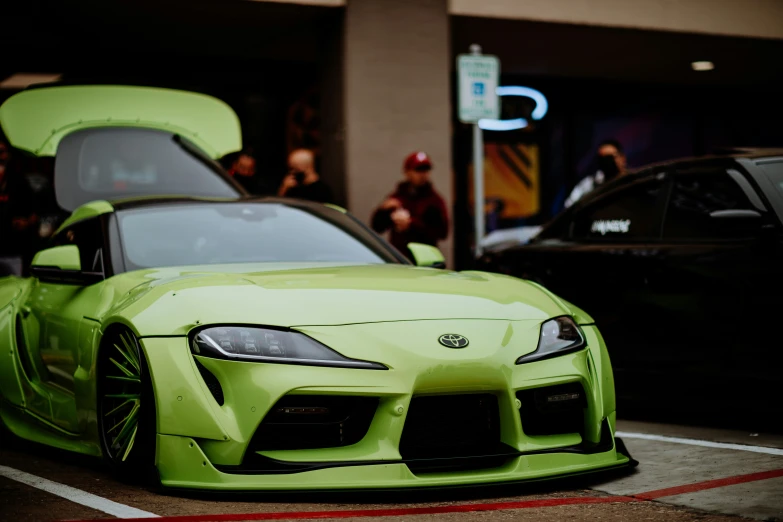 a very nice green sports car in the middle of a city