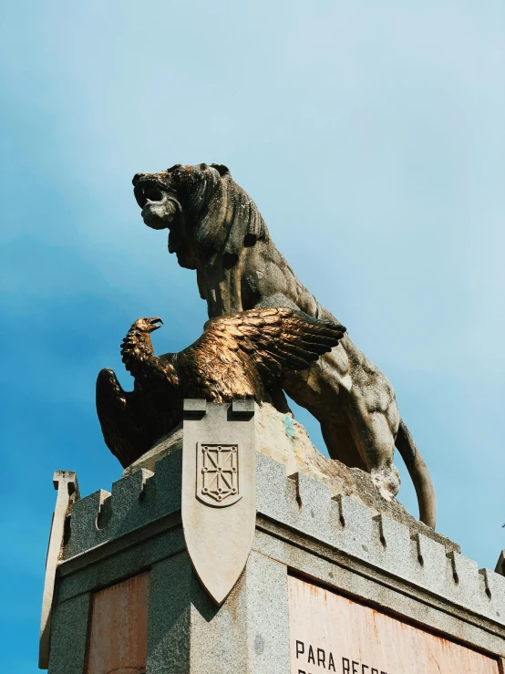 a large statue of a dog on a pedestal with two smaller figures behind it