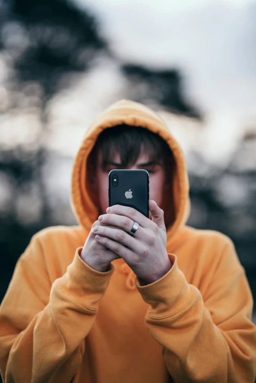 a man in a yellow jacket looking at his phone