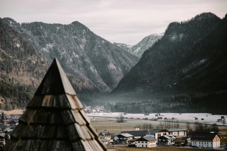 some snow mountains and houses on a cloudy day