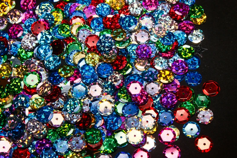 many small, colorful diamonds are scattered across the dark ground