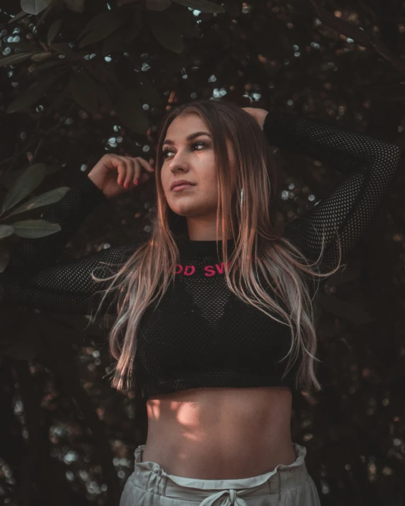 a women who is standing up in front of trees