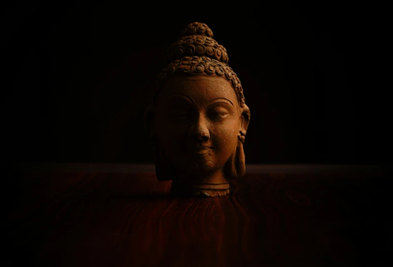 a buddha statue sitting in the dark with its eyes closed