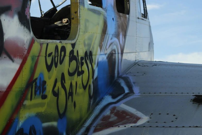 an old airplane is covered in graffiti and has it door open