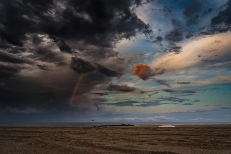 a storm moving across the sky over a beach